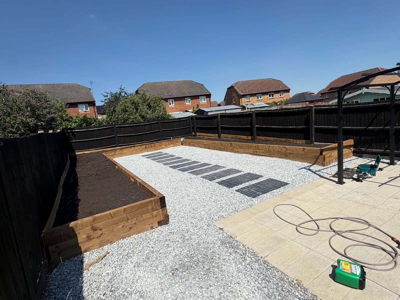 Landscaped garden with dark timber fencing, gravel and raised beds